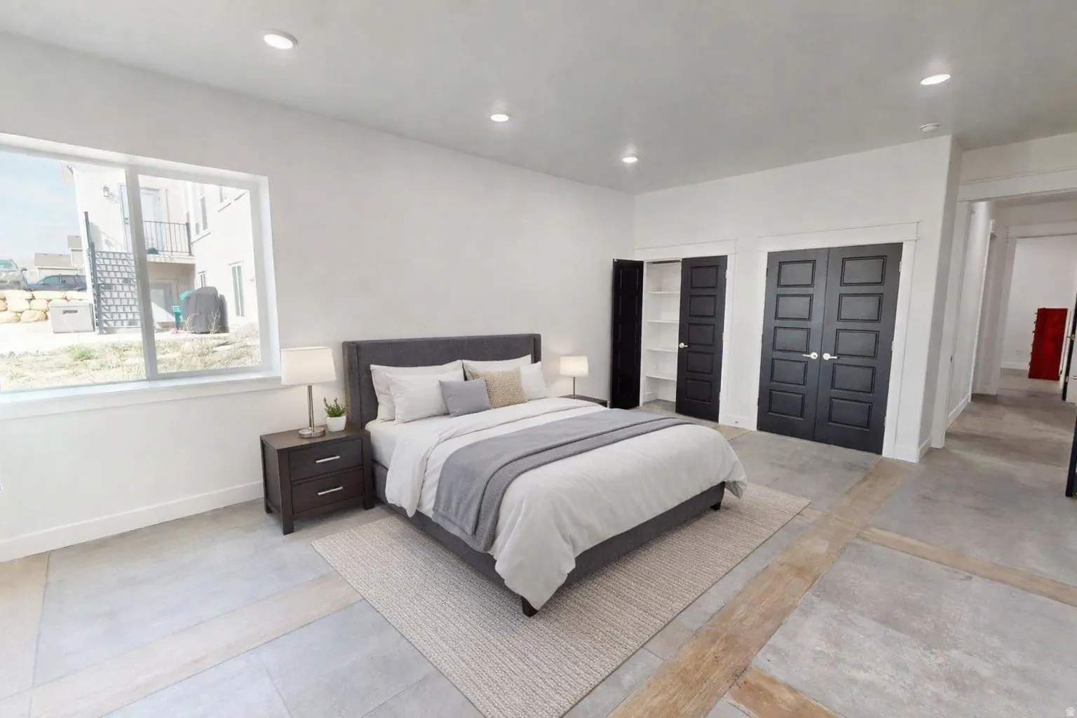 This is an Ai enhanced Photo. Recessed ceiling lighting, large window with white trim, dark paneled closet doors, built-in shelving, and light-toned flooring