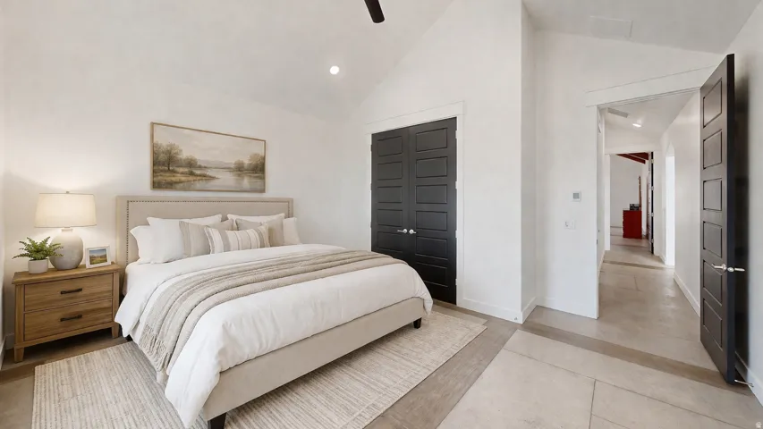 This is an Ai enhanced Photo. Vaulted ceiling, recessed lighting, ceiling fan, dark panel doors, light-toned flooring