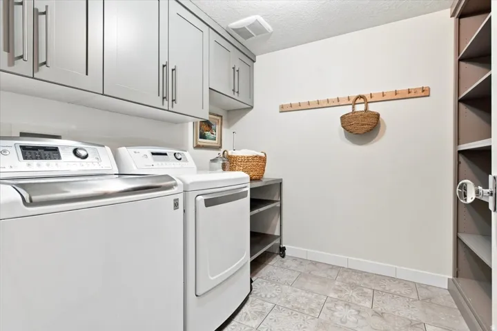 laundry room on the finished lower level with built-in cabinetry and additional storage.