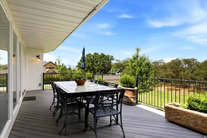 Spacious Trex deck with outdoor dining space overlooking the mature trees and surrounding landscape.