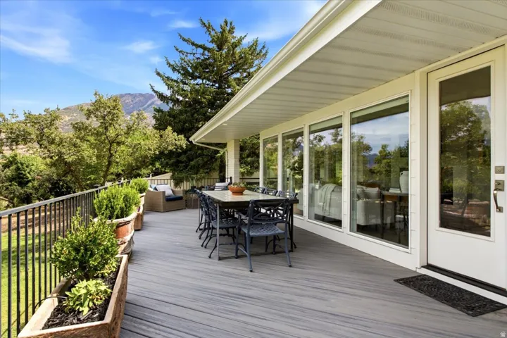 Expansive Trex deck offering outdoor living space surrounded by mature trees and mountain views.