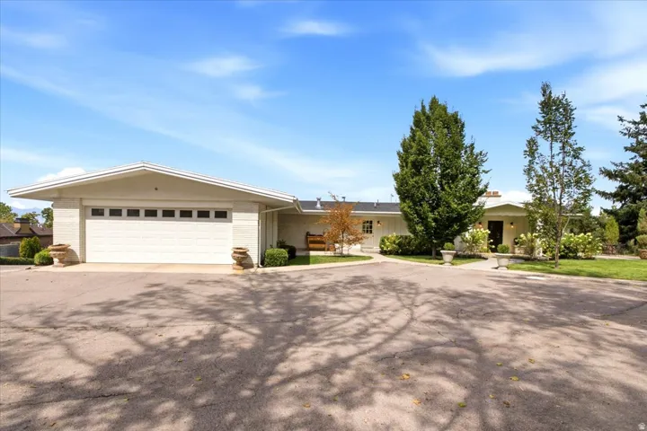 Detached two-car garage with additional driveway parking and mature landscaping.