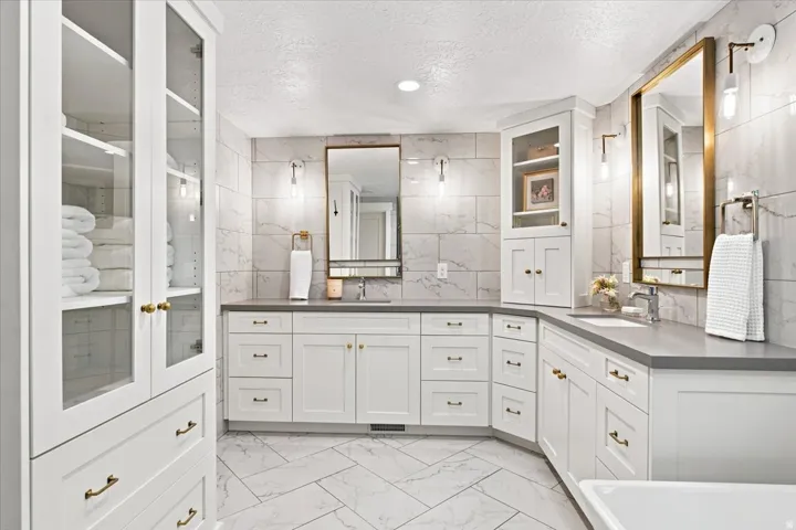 Updated primary bathroom with dual vanity, custom cabinetry, and generous storage.