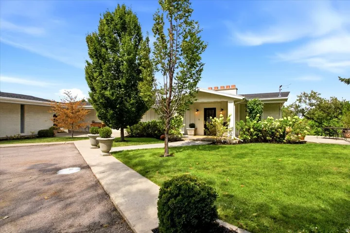 Updated Holladay ranch home with a welcoming covered entry, mature landscaping, and spacious front lawn.