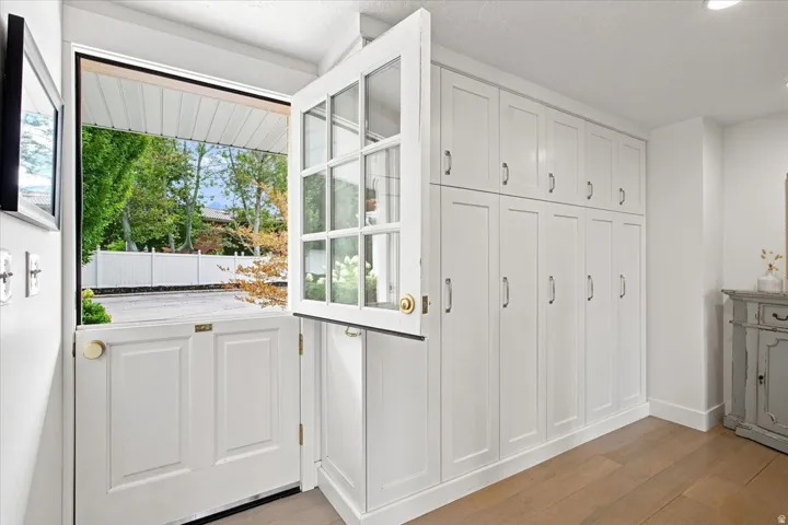 Bright mudroom with Dutch door, extensive built-in cabinetry, and convenient main-level storage.