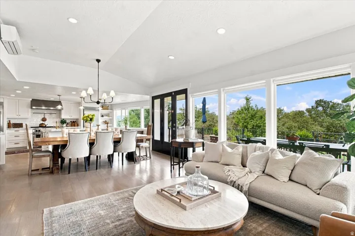 Open-concept great room connecting the kitchen, dining, and living spaces with vaulted ceilings and abundant natural light.