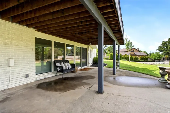 Covered walkout lower-level patio offering shaded outdoor living with direct access to the backyard.