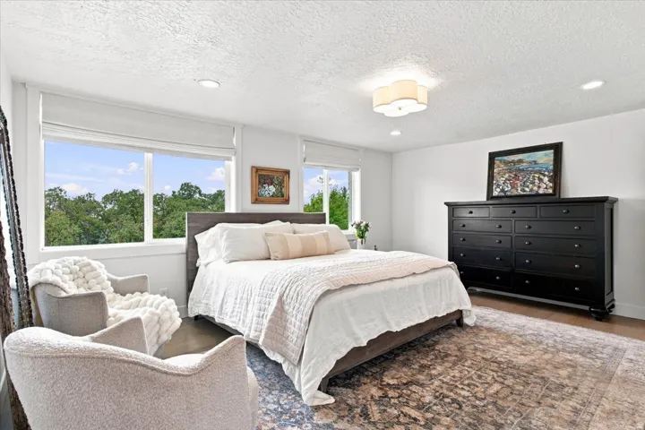 Main-level primary bedroom with mountain views, abundant natural light, and hardwood flooring.