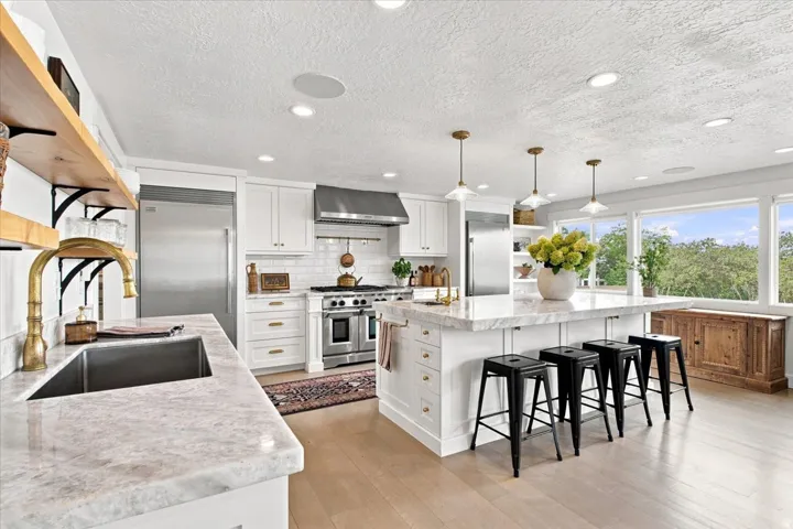 Updated gourmet kitchen with marblecountertops, expansive island, stainless steel appliances, and built-in refrigerator & freezer.