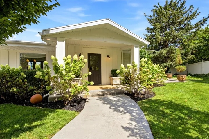 Covered front entry with mature landscaping at this secluded Holladay residence.