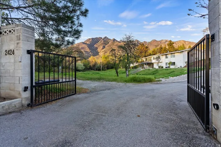 Gated entrance to Oakcrest Lane with Wasatch Mountain views beyond.