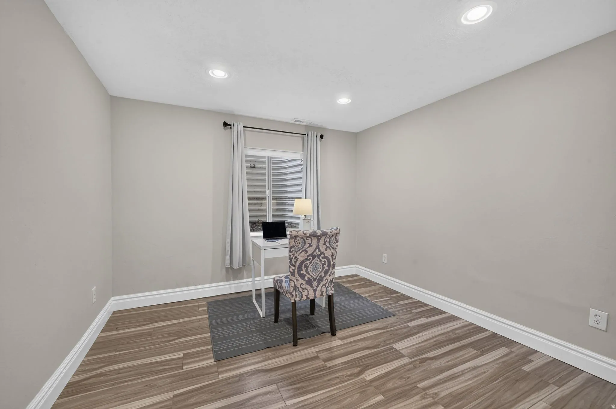 Recessed lighting, wood-finish flooring, light neutral wall paint, and white trim