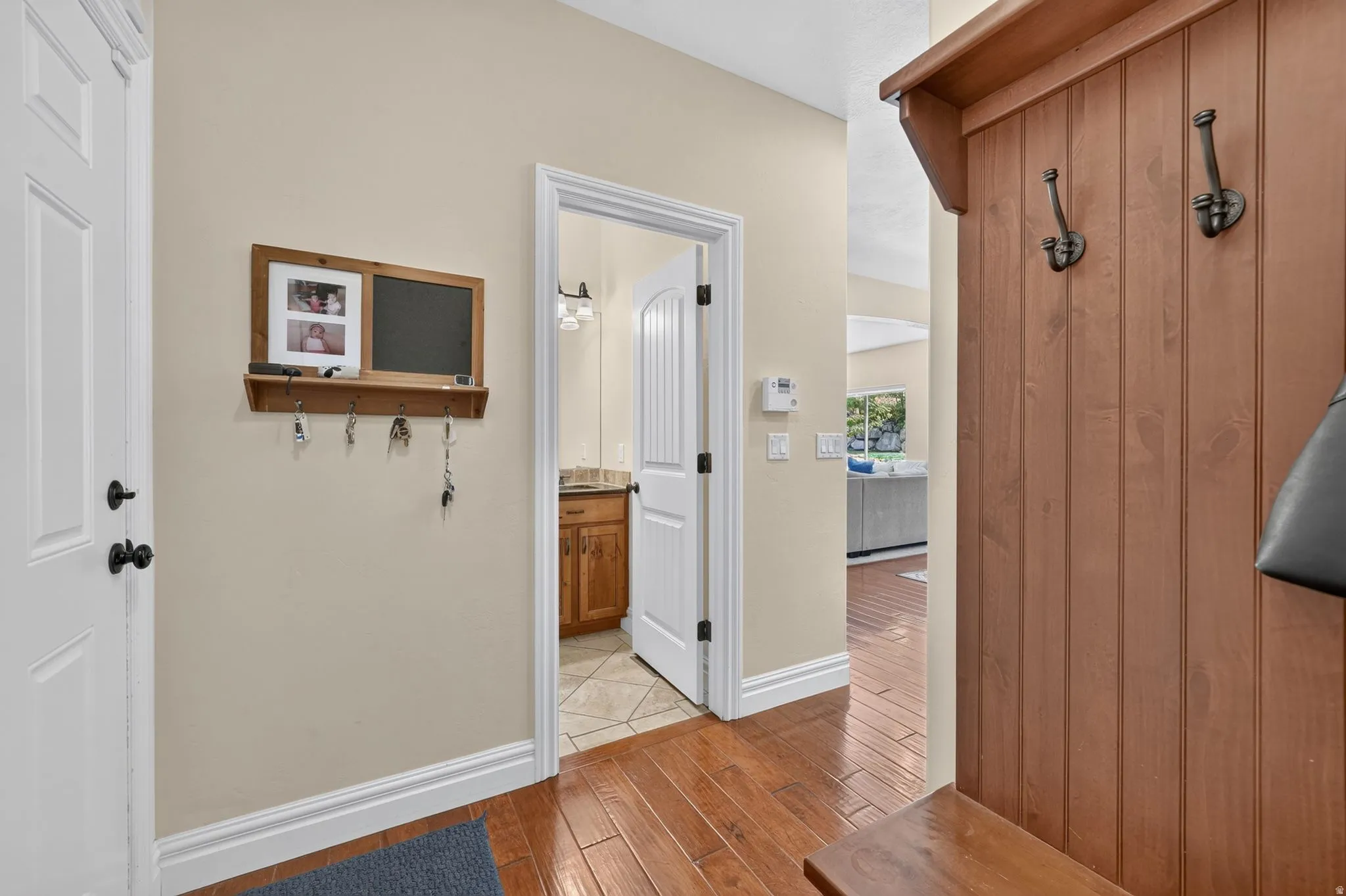 Wood-finish flooring throughout, with a built-in wooden hall tree featuring coat hooks and bench seating
