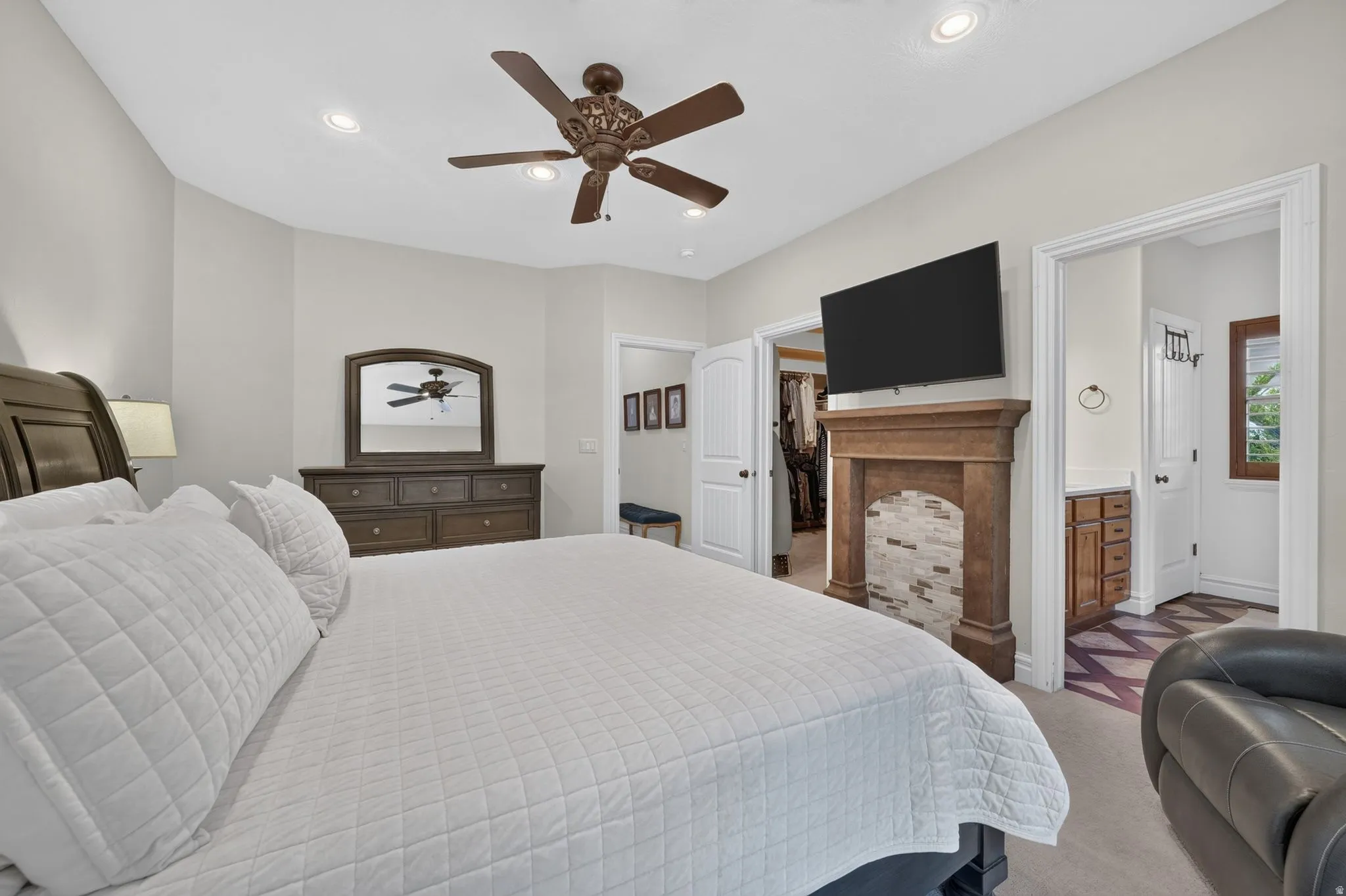 Recessed lighting, ceiling fan, wood-finish mantel with tiled surround, and direct access to an adjacent room
