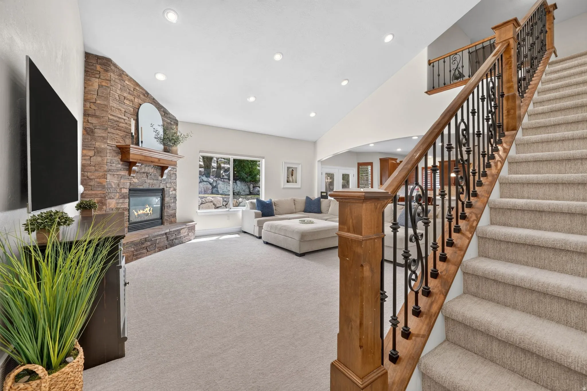 Stacked stone fireplace with a wood-finish mantel and hearth
