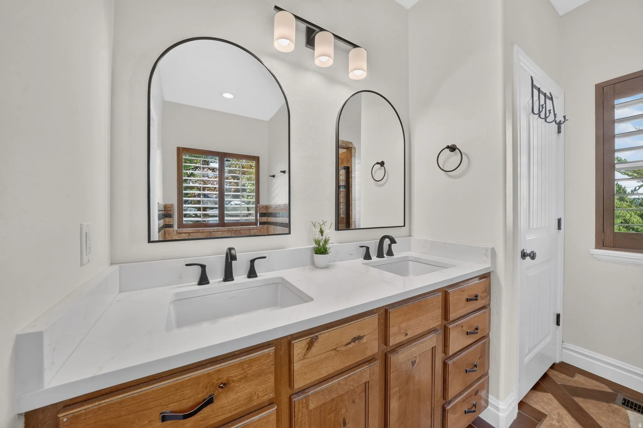 Dual vanity with white countertops, integrated sinks, and matte black fixtures