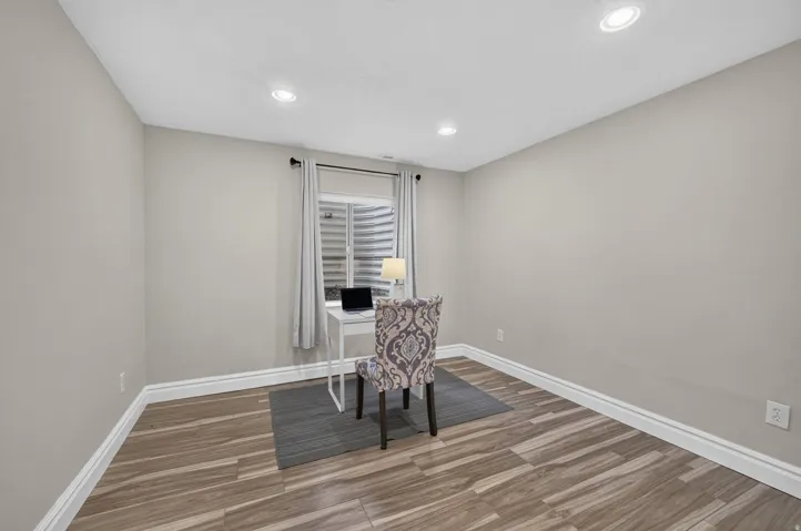 Recessed lighting, wood-finish flooring, light neutral wall paint, and white trim