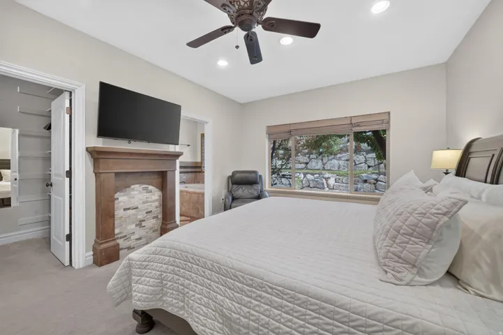 Recessed lighting, ceiling fan, wood-finish mantel with tiled hearth, large window, and carpet flooring