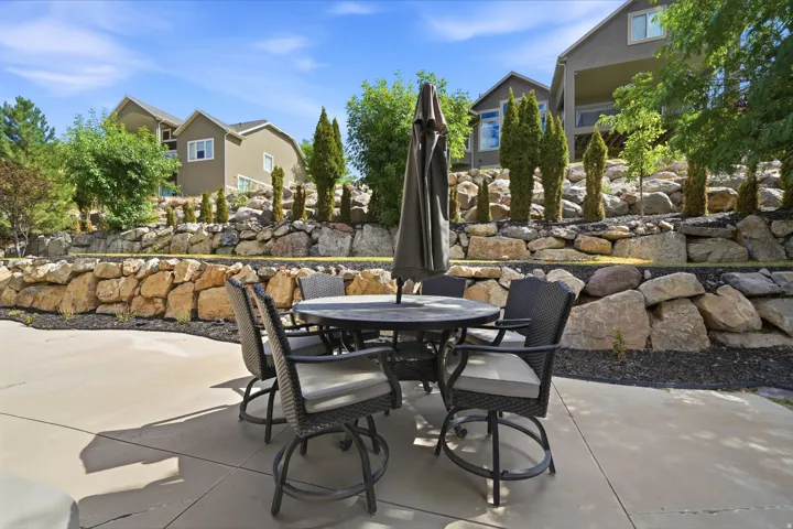 Poured concrete patio with stacked stone retaining walls and established landscaping