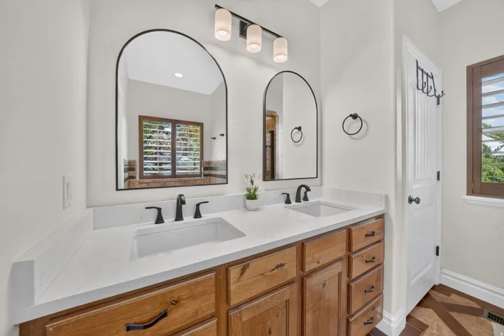 Dual vanity with white countertops, integrated sinks, and matte black fixtures