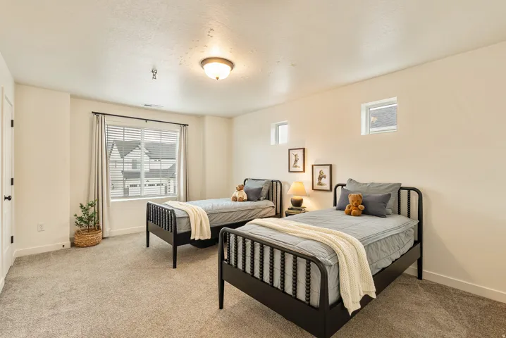 Wall-to-wall carpeting, multiple windows providing natural light, and a semi-flush mount ceiling light fixture