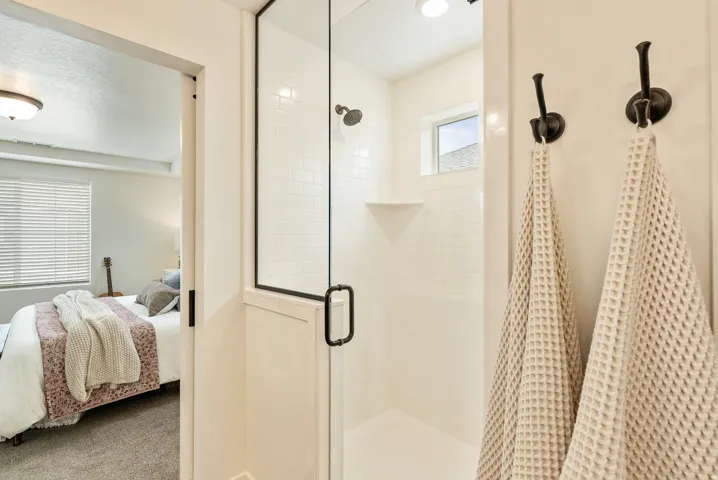 Shower enclosure with a glass door, subway tile surround, and a fixed shower head