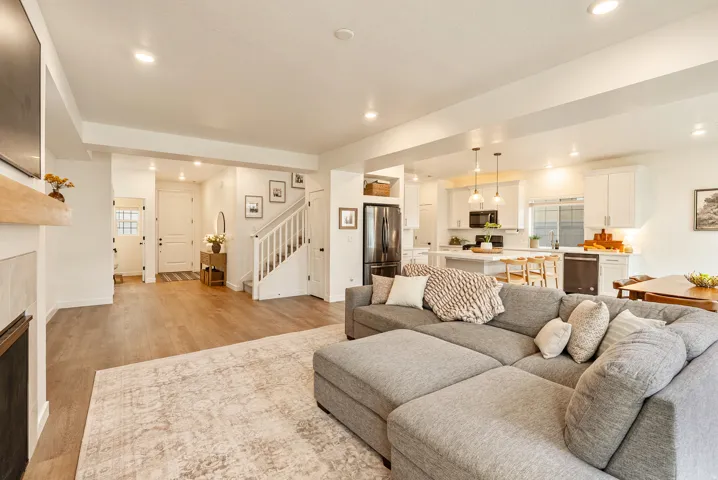 Open concept living space with wood-finish flooring, white walls, and recessed lighting