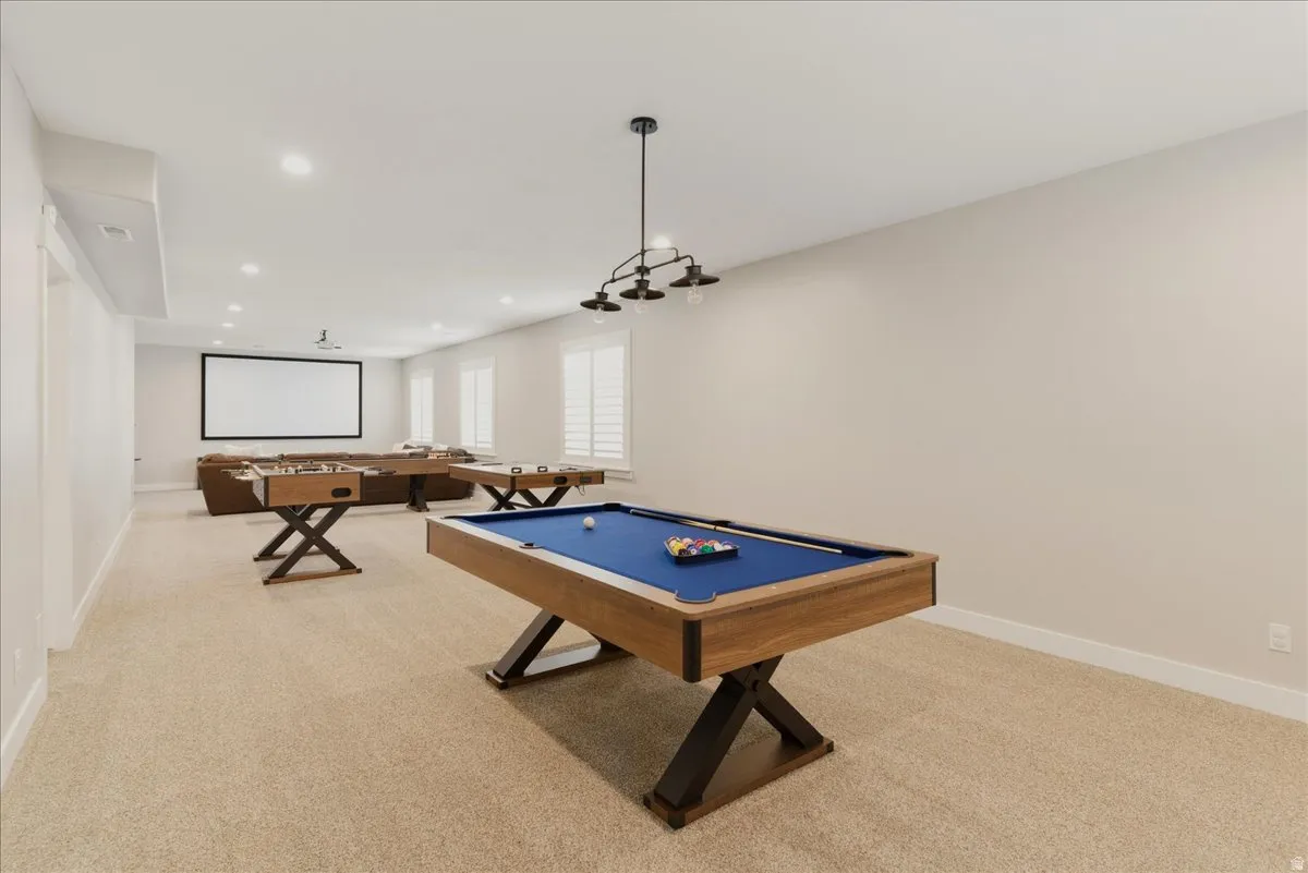 Spacious room with recessed lighting, light-toned carpeting, and multiple windows with plantation shutters
