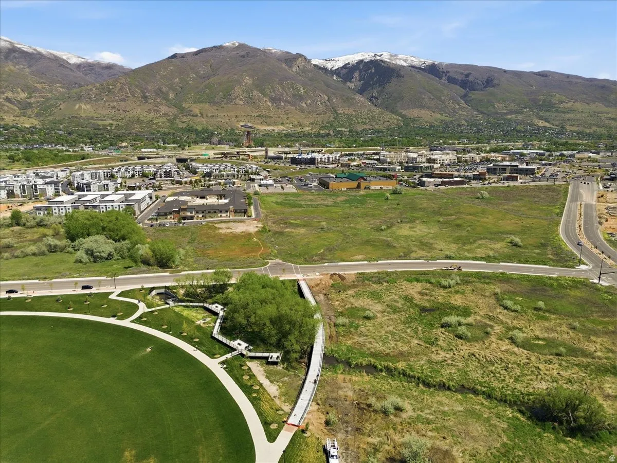 Expansive open land with paved access roads and mountain backdrop