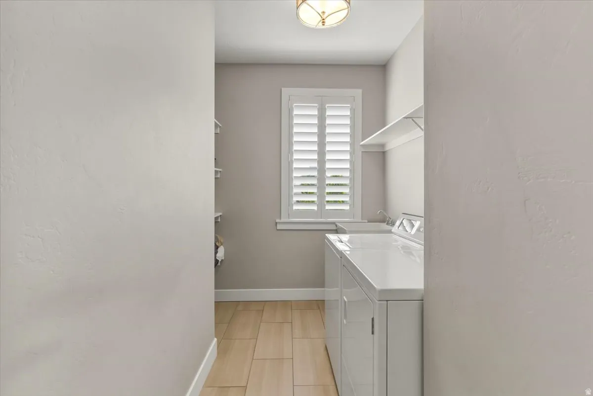 Laundry area with wood-finish flooring, white window shutters, wall-mounted shelving, and a semi-flush ceiling light