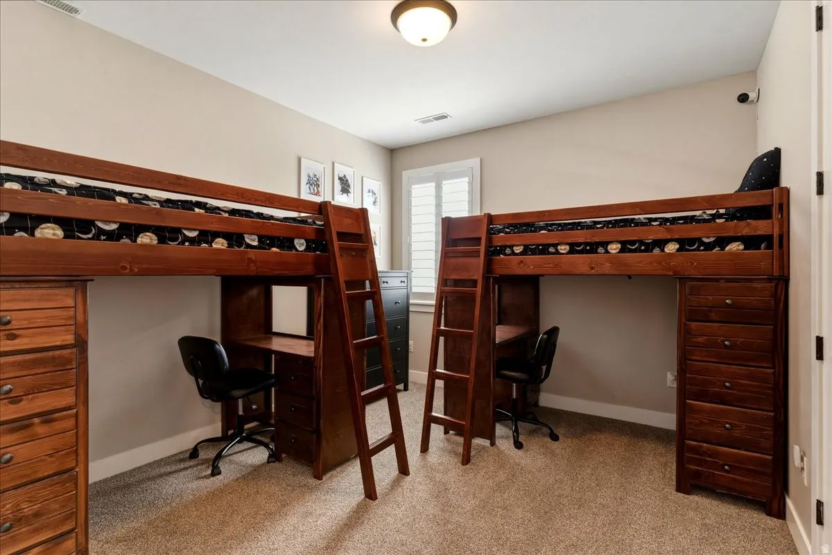 Carpeted flooring, window with plantation shutters, ceiling-mounted light fixture, and neutral wall paint