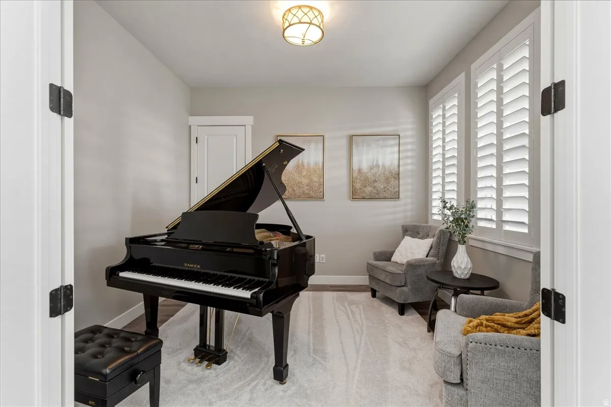 Recessed room featuring a drum chandelier, white interior doors, and two windows with plantation shutters