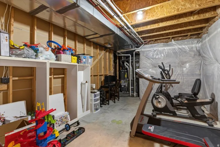 Unfinished basement space featuring exposed wood framing, concrete flooring, and visible ductwork