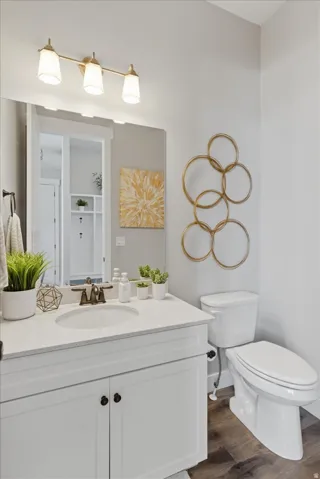 White vanity with shaker-style cabinetry, a white countertop, and an undermount sink