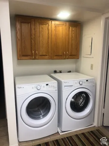 Laundry area featuring wood-finish cabinetry and overhead lighting