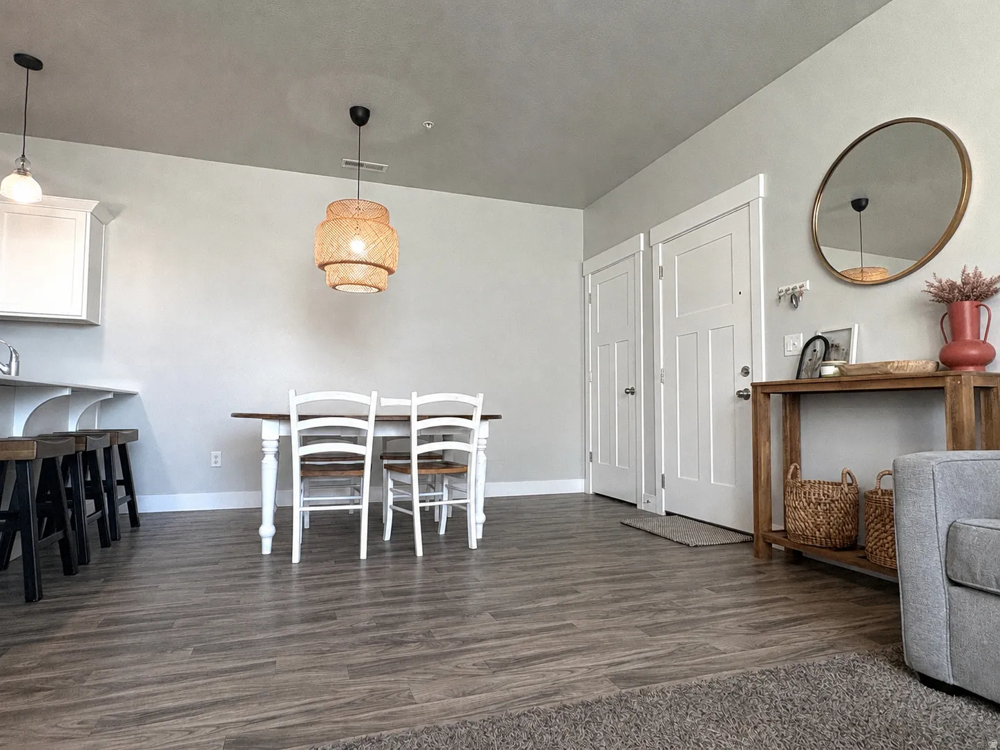 Wood-finish flooring throughout, white interior doors, and a decorative pendant light fixture