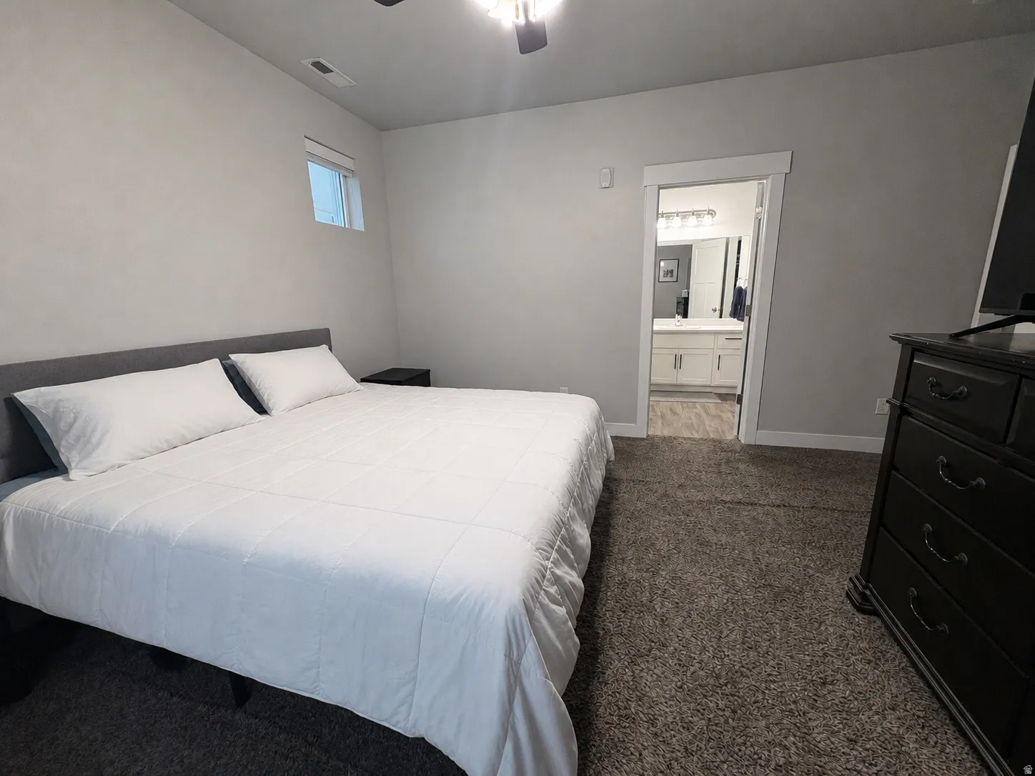 Bedroom featuring a ceiling fan with light, recessed window, and carpet flooring