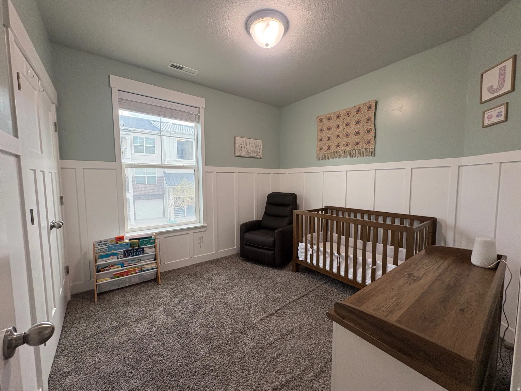 Wall-to-wall carpeting and wainscoting with a wide window trim