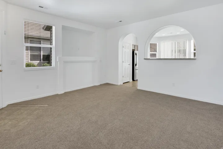 Recessed wall niche, arched pass-through window with counter, and neutral carpeting