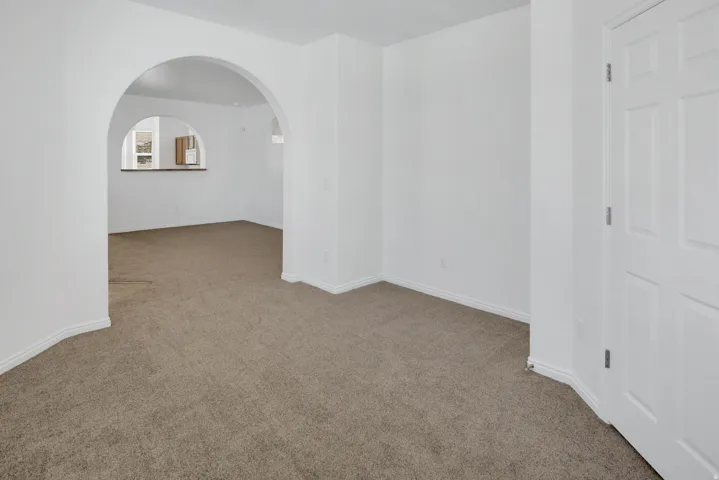 Archways define the interior spaces, featuring light neutral-toned carpet and white paneled doors
