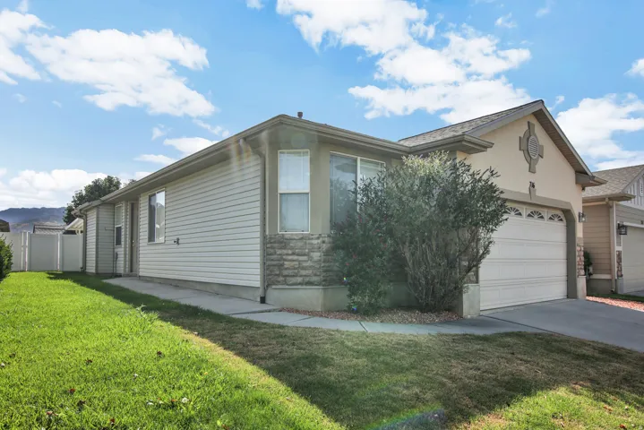 Exterior with horizontal siding, stone veneer accents, an attached garage, and a concrete driveway