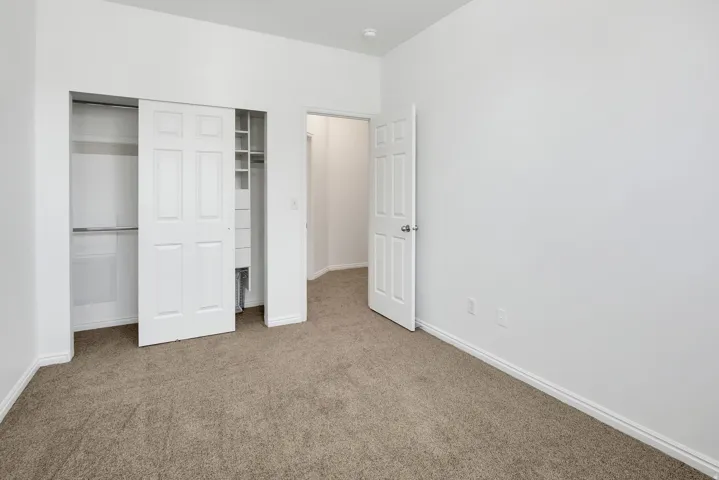 Neutral-toned carpet flooring and white painted walls