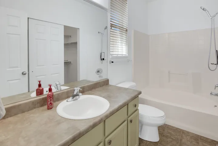 Vanity with an integrated sink, laminate countertop, and wood-finish cabinetry