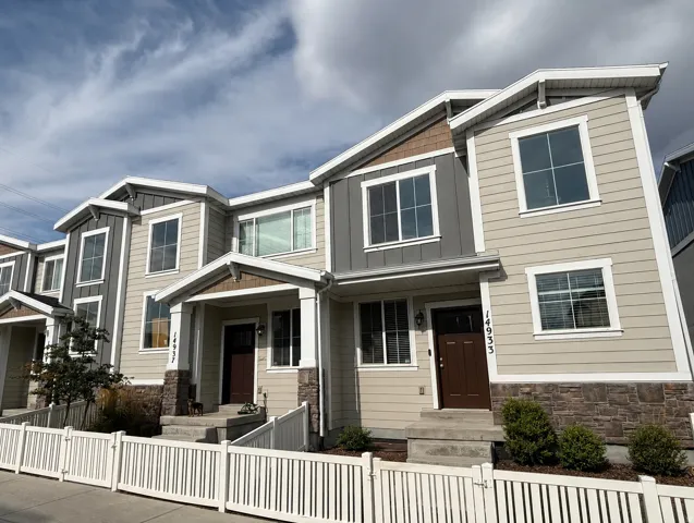 Two-story townhome with neutral-toned siding and contrasting dark grey accents