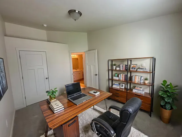 Upstairs bedroom used as office space. Carpeted room with a ceiling-mounted light fixture