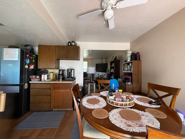Kitchen area featuring wood-finish flooring, wood cabinetry, and a ceiling fan