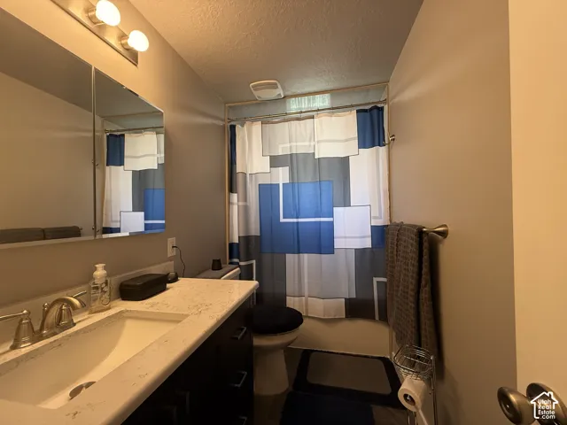 Vanity with integrated sink, dual-bulb vanity light, mirrored medicine cabinet, and a shower/tub combination