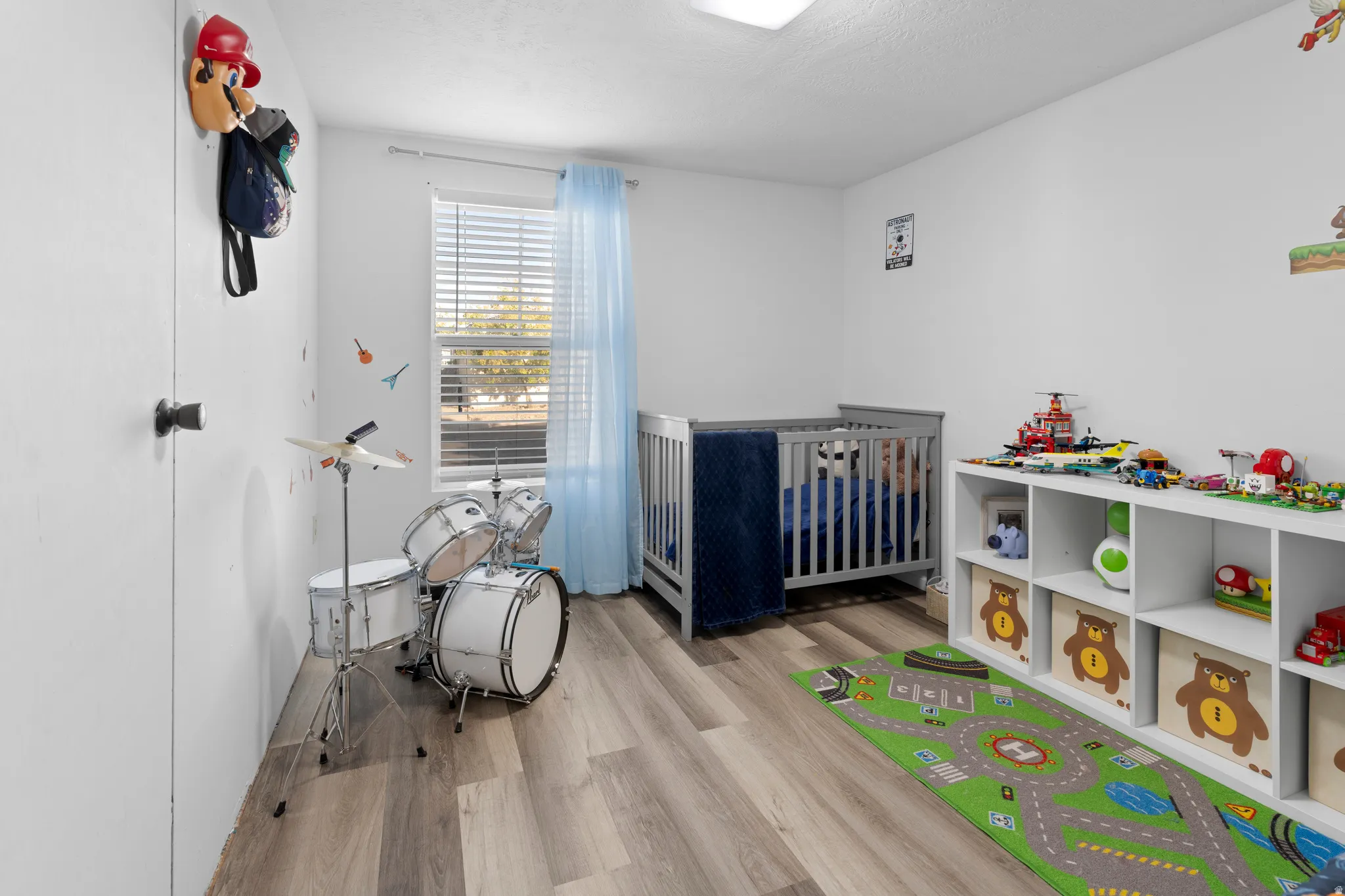 Recessed ceiling light, plank wood-finish flooring, white walls, and a window with blinds
