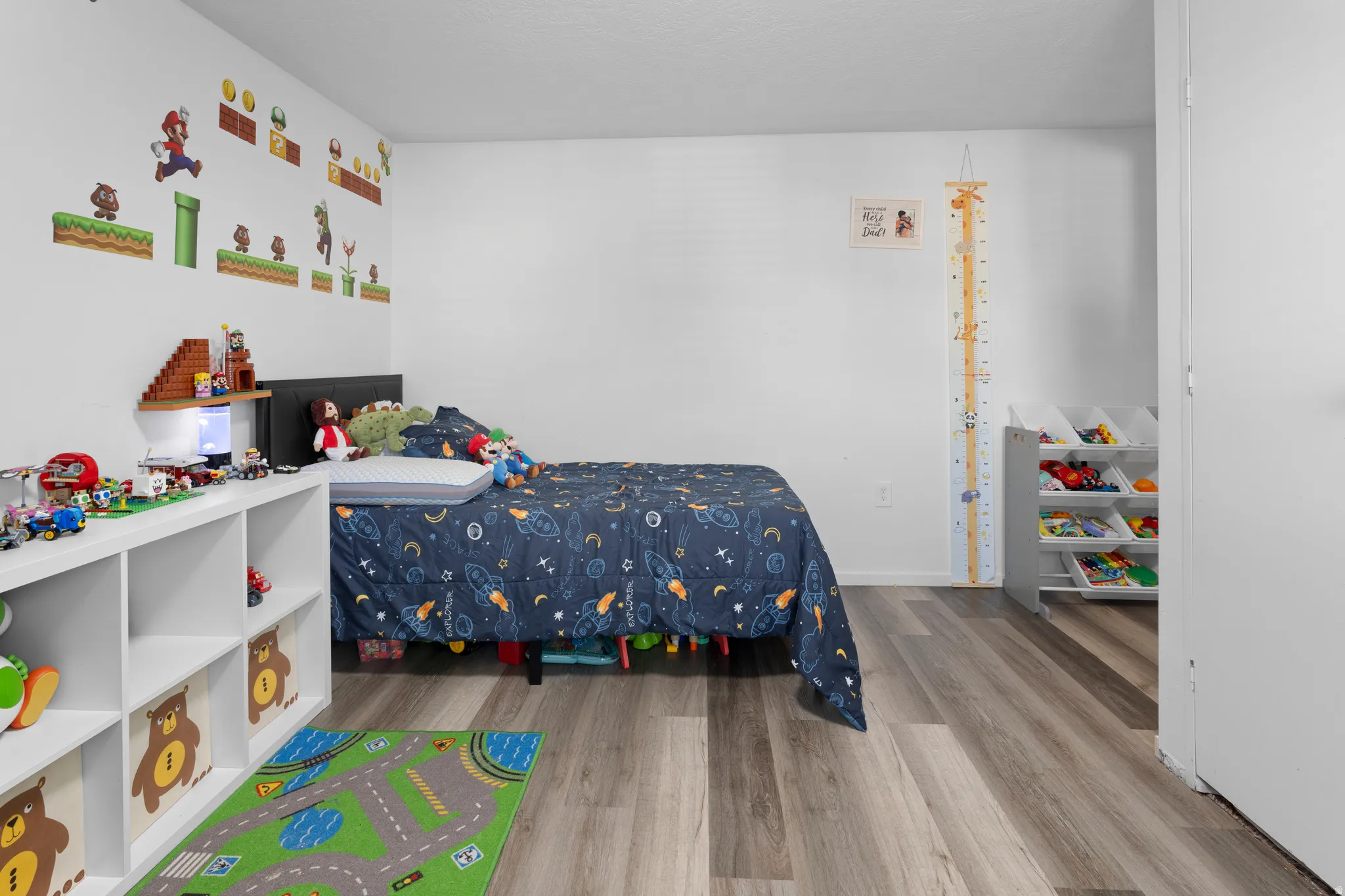 Wood-finish flooring with white walls and a white built-in storage unit