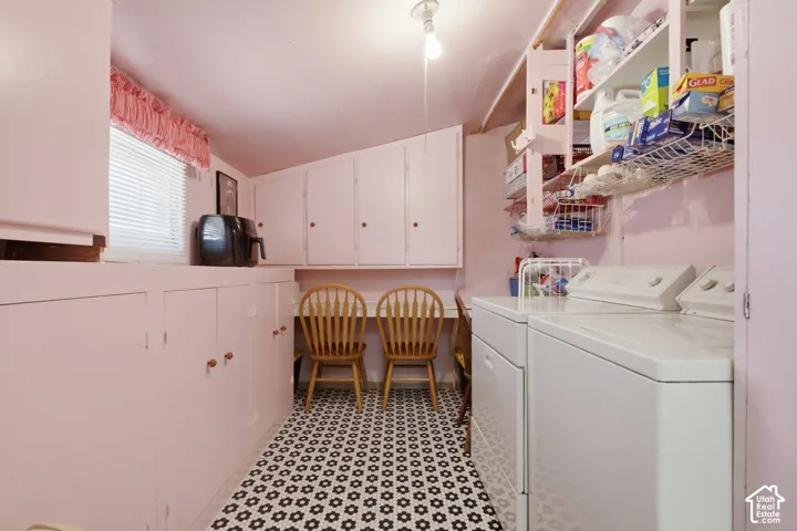 Built-in cabinetry, window with blinds, geometric tile flooring, built-in shelving, and a dedicated laundry area